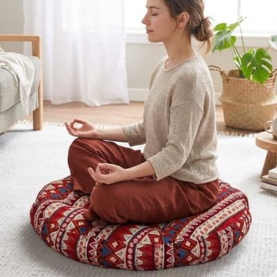 femme assise en indien sur un zafu rond
